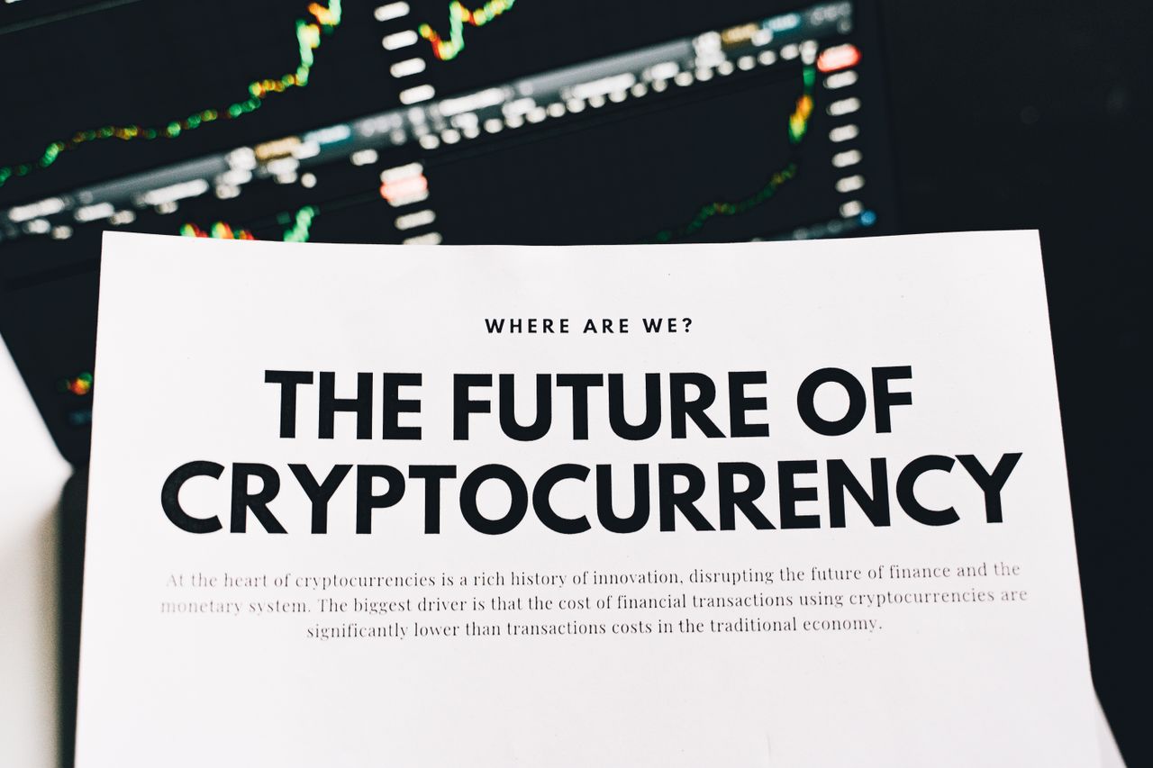 Close-up of a finance article on cryptocurrency with charts in the background.